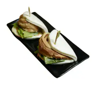 Steamed chashu bun filled with pork belly, romaine lettuce, and teriyaki sauce